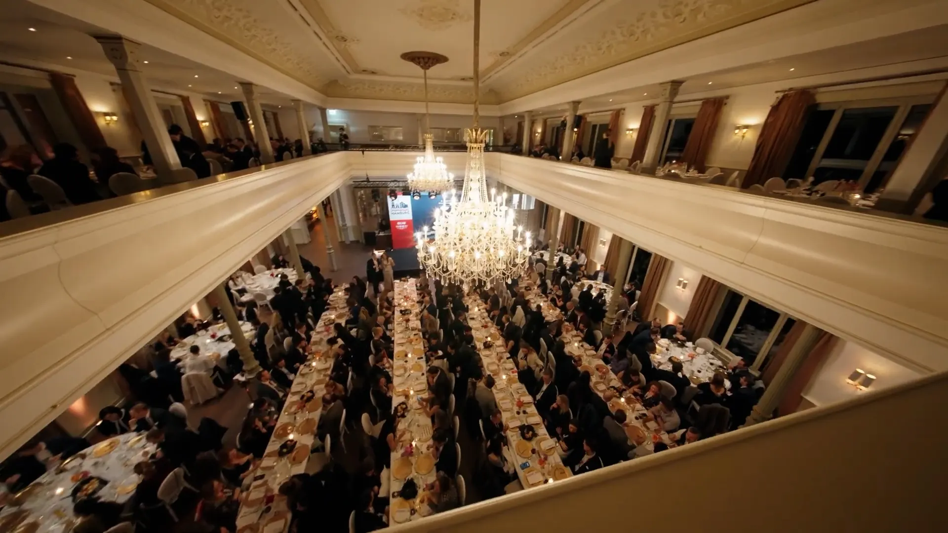 Blick von oben in den Festsaal mit langen Tafeln