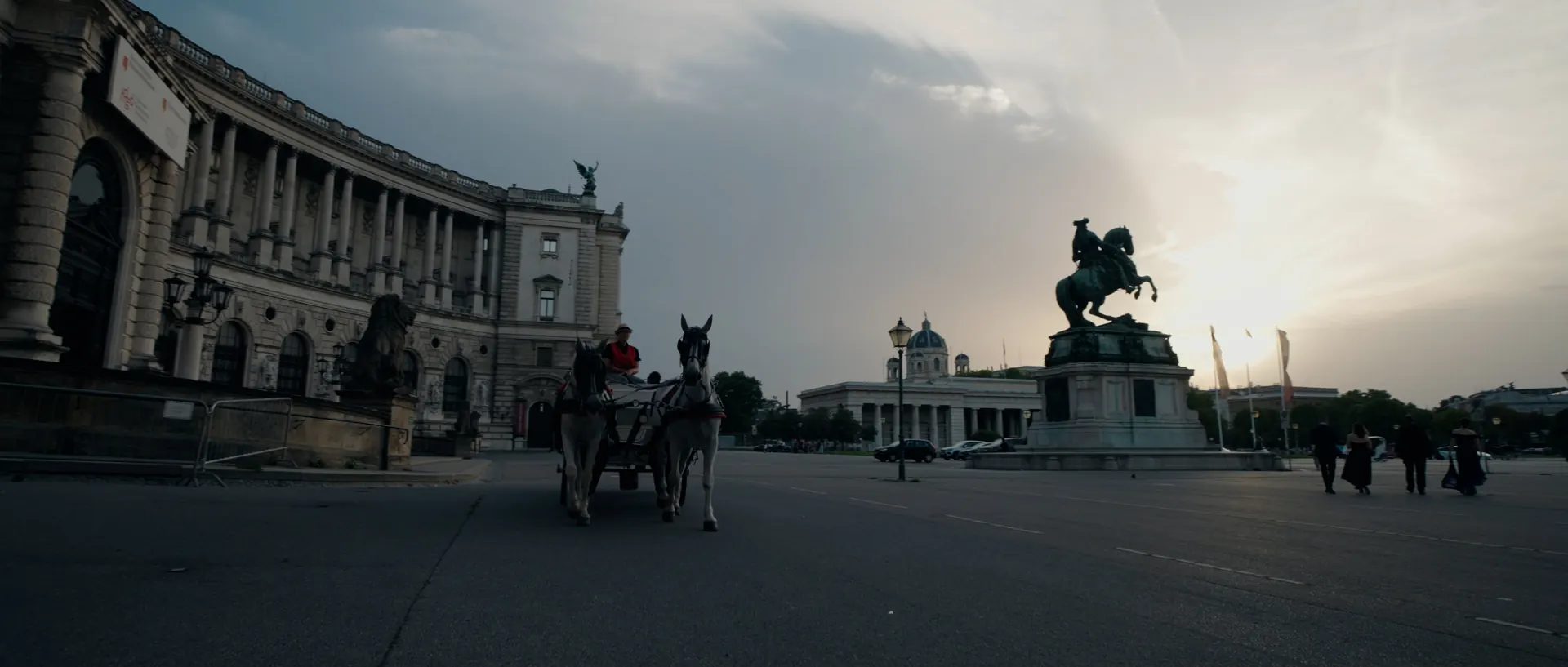 Die Hofburg am Heldenplatz im Morgenlicht, davor eine Fiakerkutsche