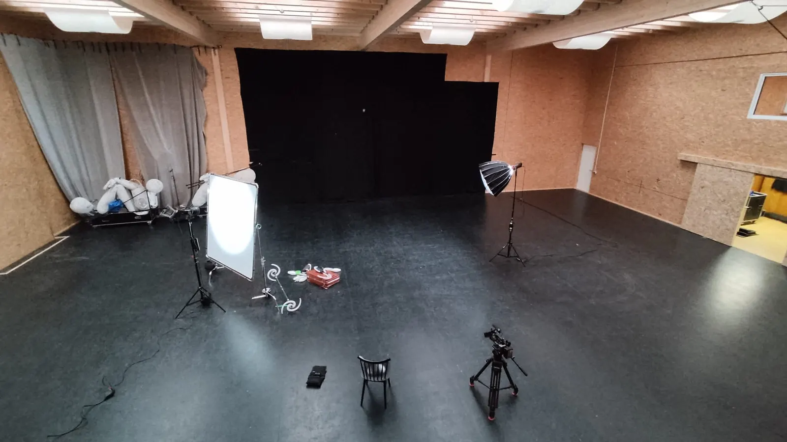 Leeres Studio mit schwarzem Hintergrund und aufgebautem Licht