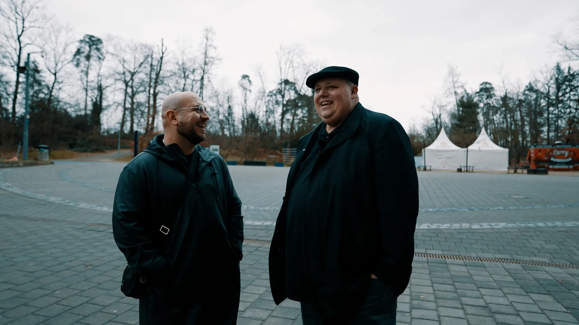 Zwei Männer im Gespräch auf einem leeren Platz im Winter