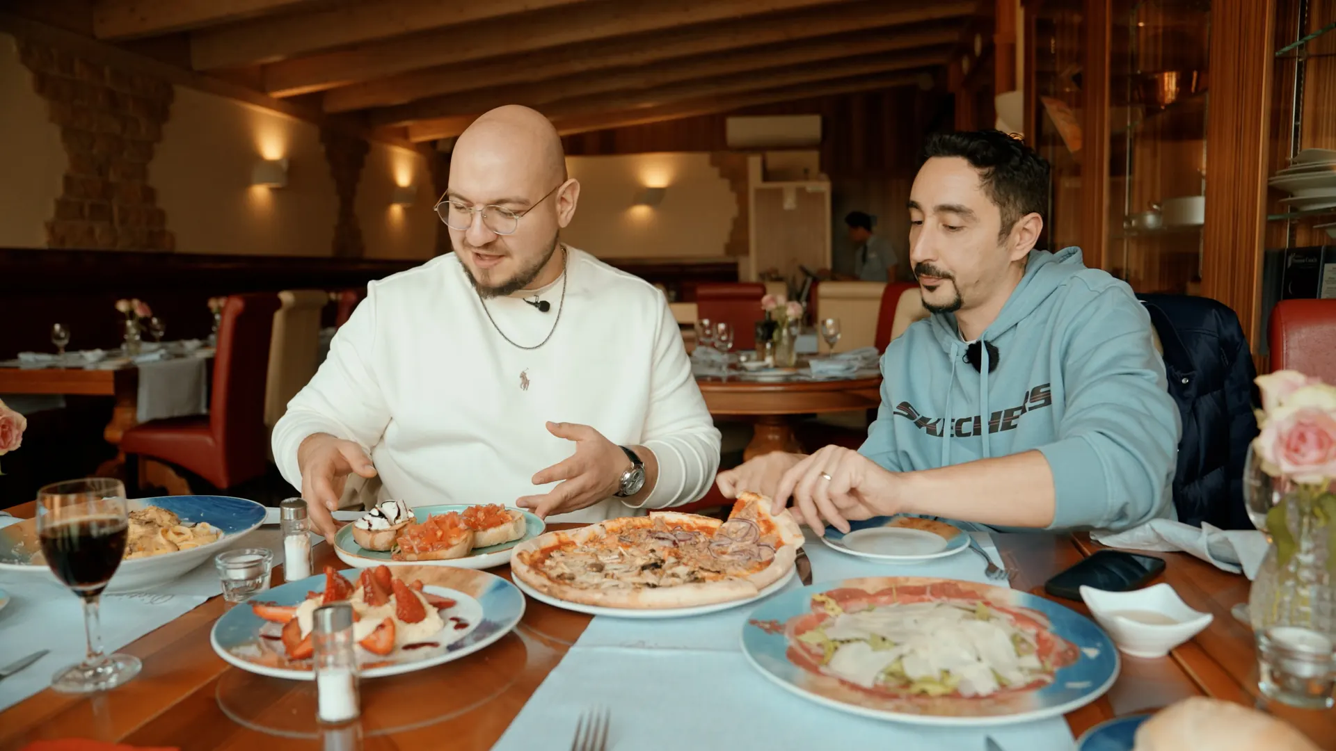 Zwei Männer essen Pizza in einer Restaurantnische