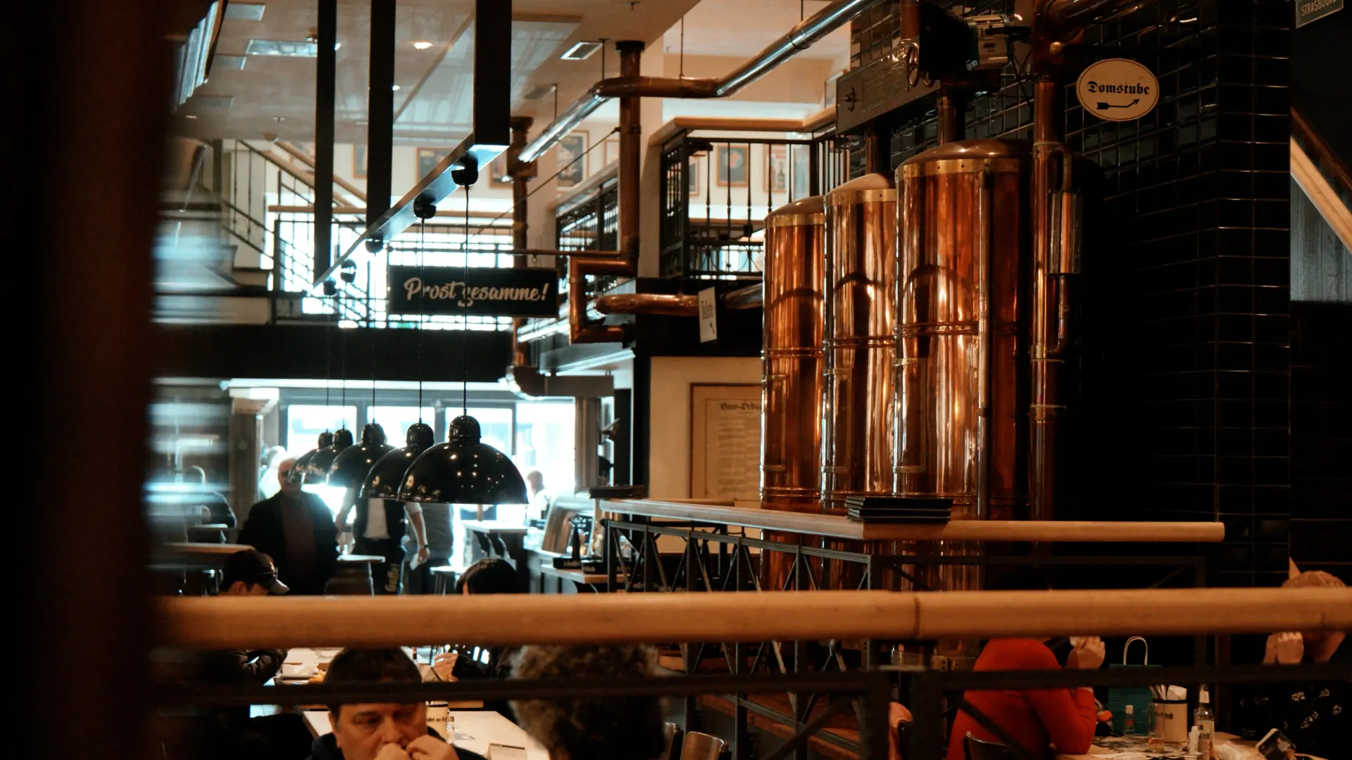 Blick über eine Brüstung auf die Kupferkessel einer Hausbrauerei