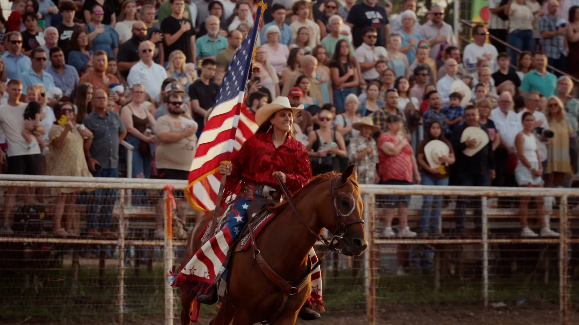 Reiterin mit Flagge auf einem Pferd in einer Rodeo-Arena
